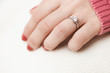 © Jirawatfoto - Close up of an elegant engagement diamond ring on woman finger with pink sweater winter clothe.