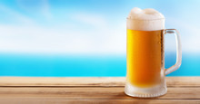 Cold Mug Of Beer On A Wooden Table On Background Of The Sea