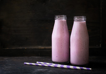 Wall Mural - bottles of blueberry smoothie on a wooden table