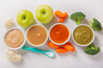 Wall Mural - Baby food. Various kinds of bowls of fruit and vegetable puree with ingredients for cooking, top view