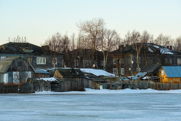 Wall Mural - House on a bank of White sea in Rabocheostrovsky, Karelia, Russia, in winter at sunset.