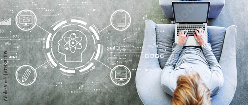 Fotografía Online education concept with man using a laptop in a modern gray chair