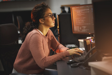 female programmer working working late at night in her office.