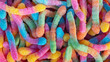 Pile of neon sugary gummy worms or  chewy sour crawlers background. Close-up of colorful and flavorsome sweet and sour treats coated in sugar crystals for bulk or individual sale at a candy store.