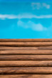 The blur sea background with wood floor foreground on horizon ; relaxing outdoors vacation with heavenly mind view at a resort deck touching sunshine, sky surf summer clouds.