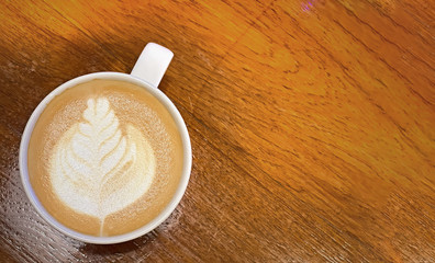 Hot art Latte Coffee in a cup on wooden table background.