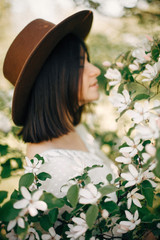 Quince white flowers on tree branch on background of blurred boho girl enjoying aroma from tree in spring garden. Cydonia oblonga tree blooming in spring orchard farm