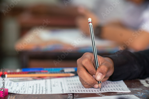 Fotografía Hand of Student doing test or exam in classroom of school with stress