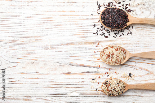 Photographie Different sorts of rice on white wooden table, flat lay