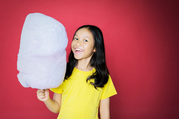 Wall Mural - Girl cheering at cam while holding a cotton candy