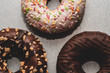 Przepyszny donut ze smacznie wyglądającymi dodatkami na szarym tle, fotografia kulinarna