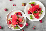 homemade raw vegan heart shaped cakes with fresh raspberries, mint, dried rose flowers and cashew. valentines day dessert
