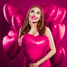 Pretty Young Woman With Makeup And Long Ginger Hair Holding Pink Heart Balloon On Pink Card Backgroud