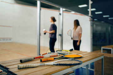 Wall Mural - Squash rackets on the table, players on background