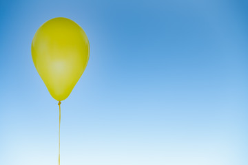 Wall Mural - Yellow balloon for birthday and celebrations isolated at blue sky