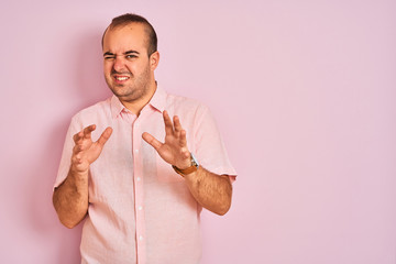 Canvas Print - Young man wearing elegant shirt standing over isolated pink background disgusted expression, displeased and fearful doing disgust face because aversion reaction. With hands raised. Annoying concept.