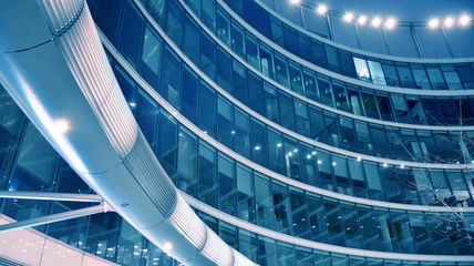 Night architecture - building with glass facade. Modern building in  business district. Concept of economics, financial. Photo of commercial office building exterior. Abstract image of office building