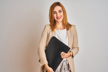 Redhead business caucasian woman holding work case over isolated background with a happy face standing and smiling with a confident smile showing teeth