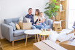 © Krakenimages.com - Beautiful family with kid sitting on the sofa drinking coffee at new home around cardboard boxes