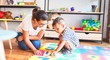 © Krakenimages.com - Beautiful teacher and toddler boy sitting on puzzle playing with numbers at kindergarten
