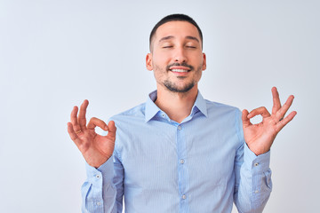 Wall Mural - Young handsome business man standing over isolated background relax and smiling with eyes closed doing meditation gesture with fingers. Yoga concept.