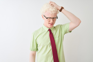 Wall Mural - Young albino businessman wearing shirt and tie standing over isolated white background confuse and wonder about question. Uncertain with doubt, thinking with hand on head. Pensive concept.