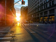 Crowds of busy people walking across an intersection in Midtown Manhattan New York City with sunlight background