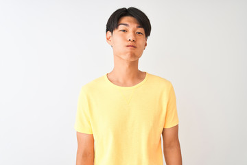 Wall Mural - Chinese man wearing yellow casual t-shirt standing over isolated white background puffing cheeks with funny face. Mouth inflated with air, crazy expression.