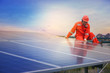 © Panumas - Electrical and instrument technician installation and maintenance electric system at solar panel field with sunset background.