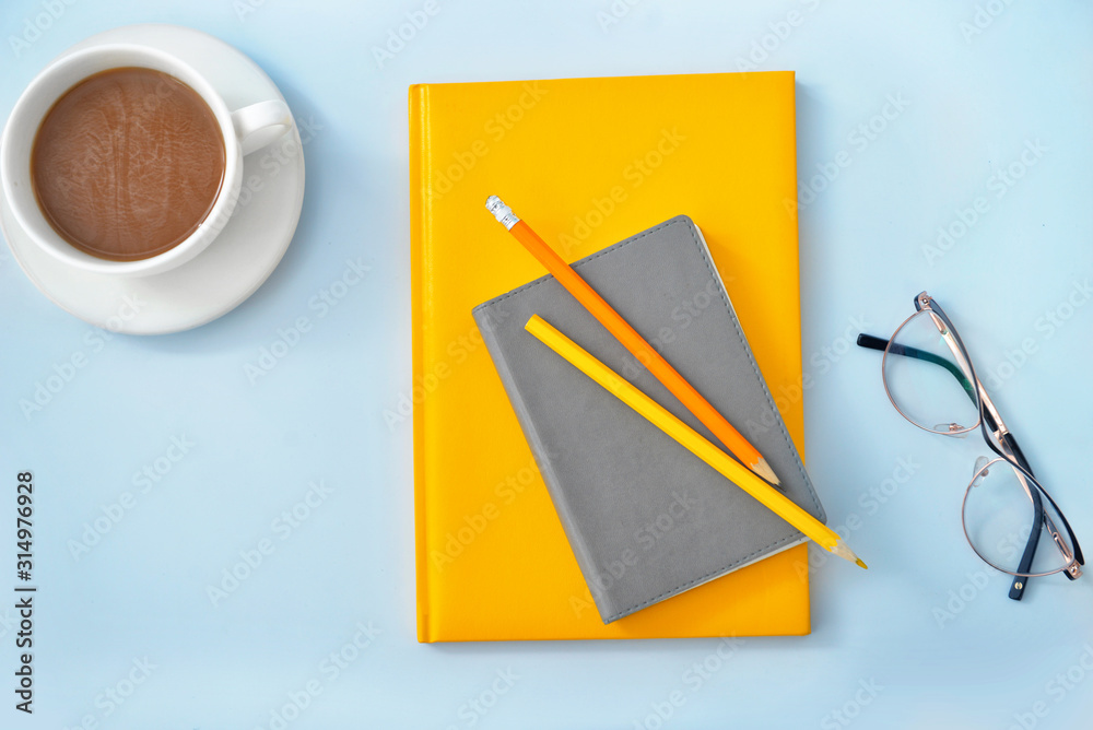 Stylish notebooks with cup of coffee and pencils on white background