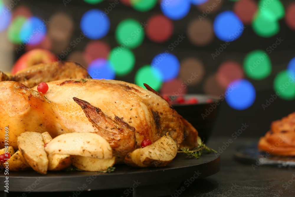 Tasty baked turkey for Thanksgiving day on table against blurred lights