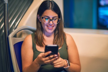 Sticker - Young beautiful woman smiling happy and confident. Sitting with smile on face using smartphone travelling by bus