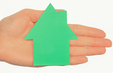 Hand of woman with shape of green house. Ecology house