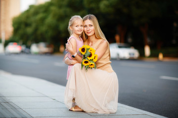 Wall Mural - Portrait of beautiful woman and girl with sunflowers