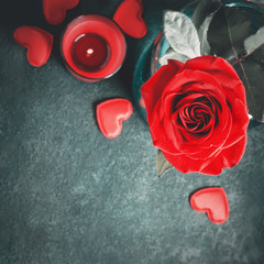 Love greeting card concept. Red rose and candle on gray background