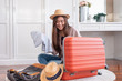 © weedezign - Young asian woman traveler prepare cloth and stuff into orange suitcase for holiday vacation at home.backpacker travel concept