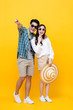 © Atstock Productions - Excited young Asian couple tourist in colorful yellow background
