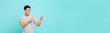 © Atstock Productions - Cheerful smiling young Asian man pointing hands to copy space aside