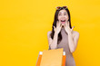 © Atstock Productions - Young Asian woman carrying colorful shopping bags in surprised and excited gesture