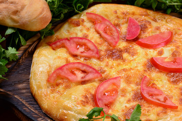 Ossetian Khachapuri cheese pie. Georgian traditional Chakhragina khachapuri, Ossetian pie with potatoes cheese tomatoes.