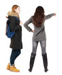 © ghoststone - Back view of two pointing young girl in winter jacket.