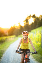 Pretty, Young Woman Biking On A Mountain Bike Enjoying Healthy Active Lifestyle Outdoors In Summer (shallow DOF)