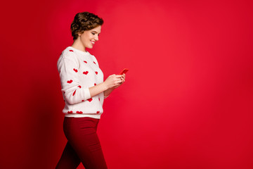 Poster - Profile side view portrait of her she nice attractive lovely charming addicted cheerful cheery girl walking using device sending sms isolated over bright vivid shine vibrant red color background