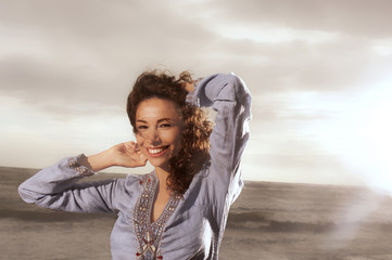 Wall Mural - Ragazza sorridente al mare sotto la pioggia e con i capelli al vento