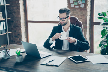 Poster - Photo of handsome business chief guy holding hot coffee beverage mug looking notebook screen talking skype relatives wear specs black blazer shirt suit sit chair office indoors