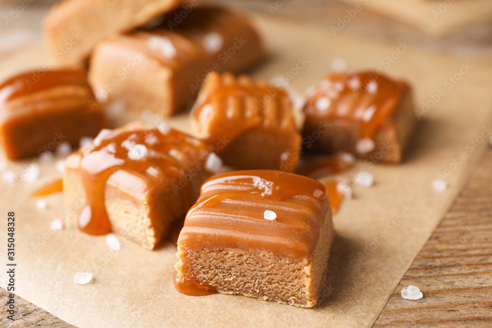 Salted caramel on wooden table, closeup view - obrazy, fototapety, plakaty 