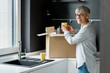 © LIGHTFIELD STUDIOS - smiling mature woman unpacking box in new house