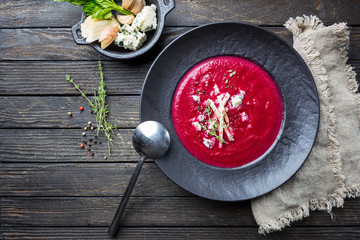 Poster - Cold Beetroot mashed soup with cream, apple, cheese and thyme in a dark bowl over wooden background, top view.