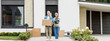 © LIGHTFIELD STUDIOS - panoramic shot of mature man holding box and woman holding plant near new house