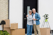 © LIGHTFIELD STUDIOS - smiling mature man and woman hugging near new house